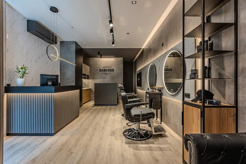 Interior de un local con paneles efecto mármol, lamas de madera en el mostrador, estanterías negras y suelo de madera clara
